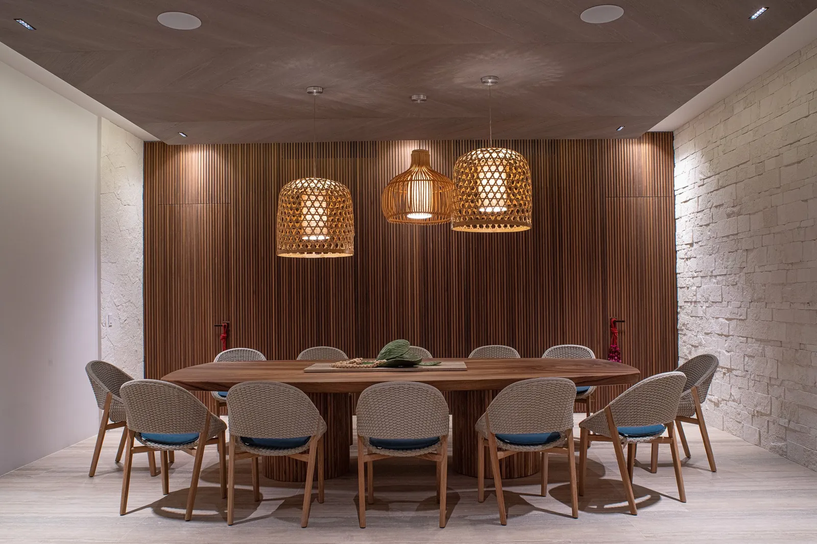 The dining room with its wooden table and woven pendant lamps