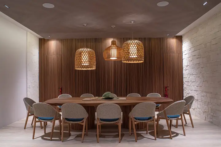 The dining room with its wooden table and woven pendant lamps