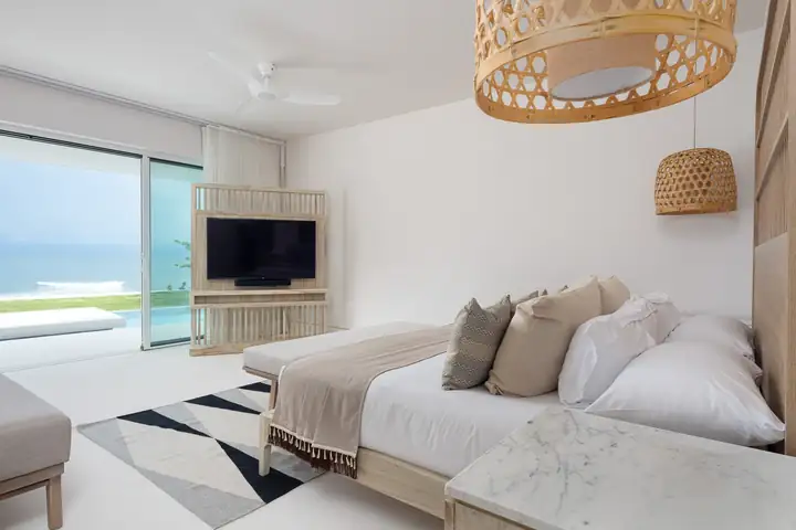 Ocean View Suite 4: the bed facing the glass wall to the infinity pool