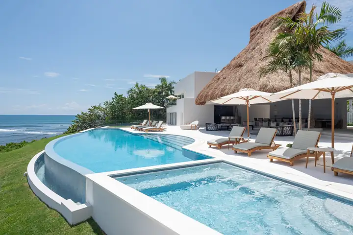 The pool terrace and the palapa on the edge of the lawn