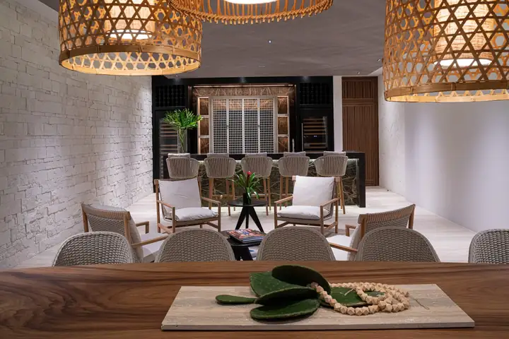 The pub lounge with armchairs, the bar and a wall of bottles