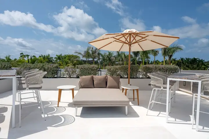 A daybed under an umbrella on the rooftop terrace