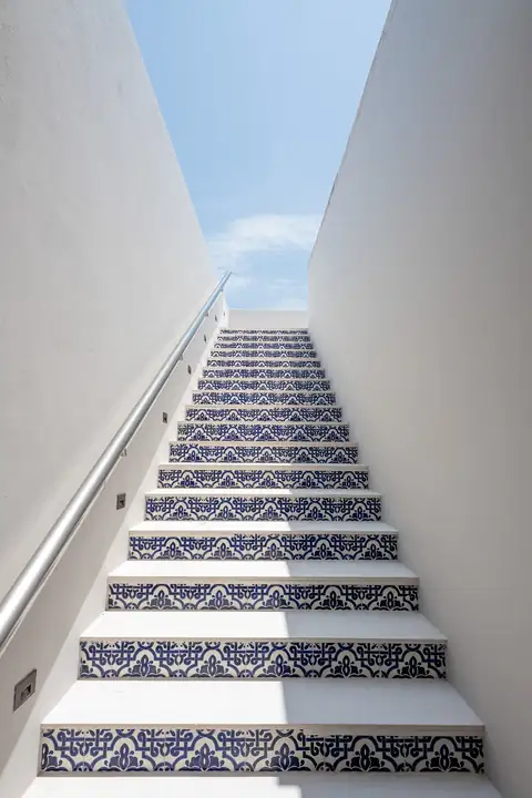 The blue-and-white tiled stair to the rooftop terrace